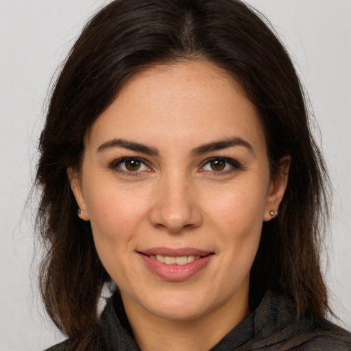 Joyful white young-adult female with long  brown hair and brown eyes