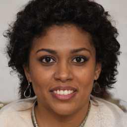 Joyful black young-adult female with long  brown hair and brown eyes