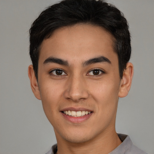 Joyful latino young-adult male with short  black hair and brown eyes