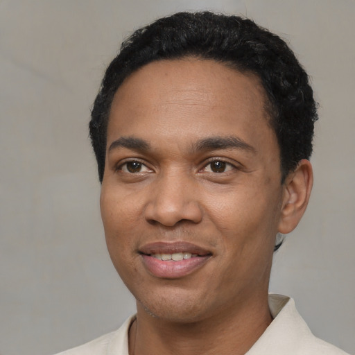 Joyful black adult male with short  black hair and brown eyes