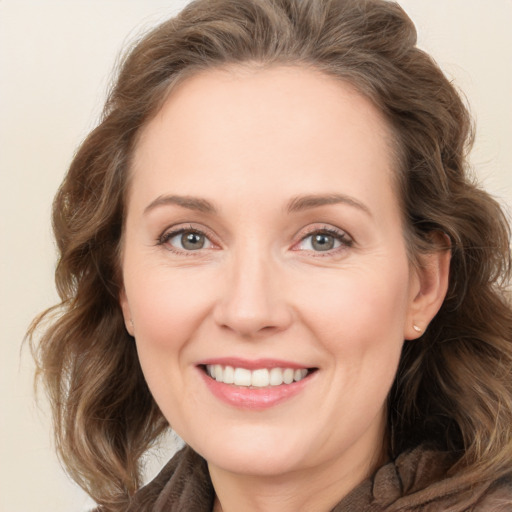 Joyful white adult female with medium  brown hair and blue eyes