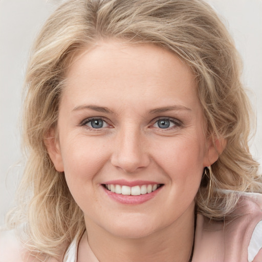 Joyful white young-adult female with medium  blond hair and blue eyes