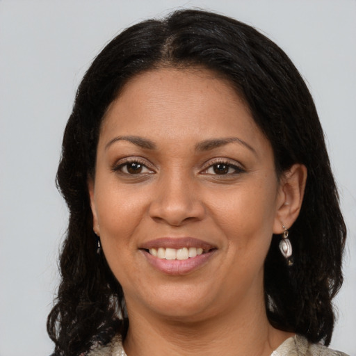 Joyful latino young-adult female with medium  brown hair and brown eyes