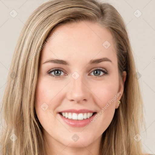 Joyful white young-adult female with long  brown hair and green eyes