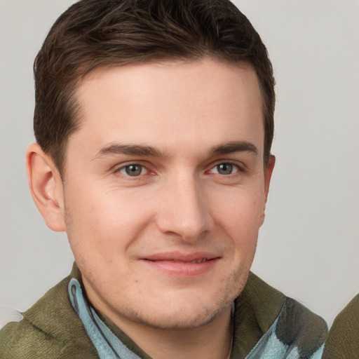 Joyful white young-adult male with short  brown hair and grey eyes