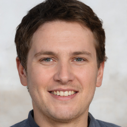 Joyful white adult male with short  brown hair and grey eyes