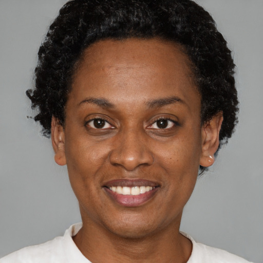 Joyful black adult female with short  brown hair and brown eyes