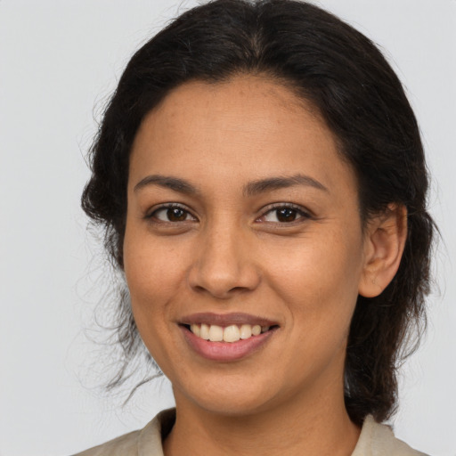 Joyful latino adult female with medium  brown hair and brown eyes