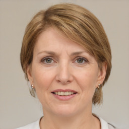 Joyful white adult female with medium  brown hair and grey eyes