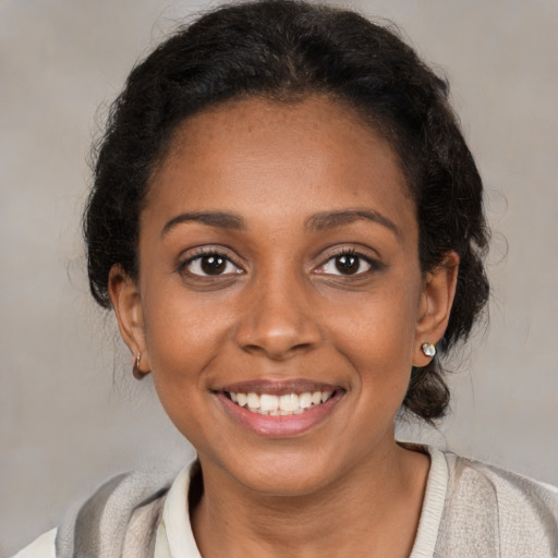 Joyful black young-adult female with medium  brown hair and brown eyes