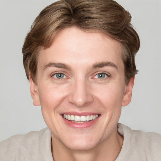 Joyful white young-adult female with short  brown hair and grey eyes