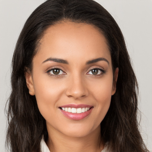 Joyful white young-adult female with long  brown hair and brown eyes