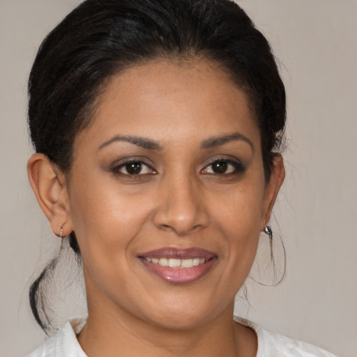 Joyful latino adult female with medium  brown hair and brown eyes