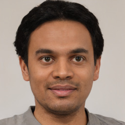 Joyful latino young-adult male with short  black hair and brown eyes