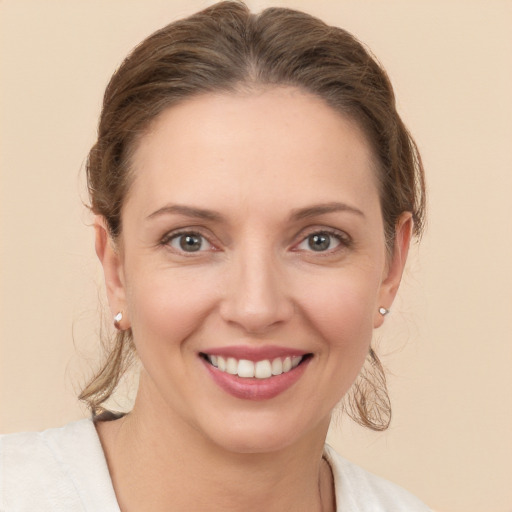 Joyful white young-adult female with medium  brown hair and grey eyes