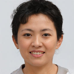 Joyful asian young-adult female with short  brown hair and brown eyes