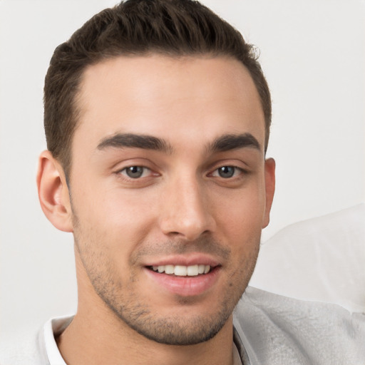 Joyful white young-adult male with short  brown hair and brown eyes