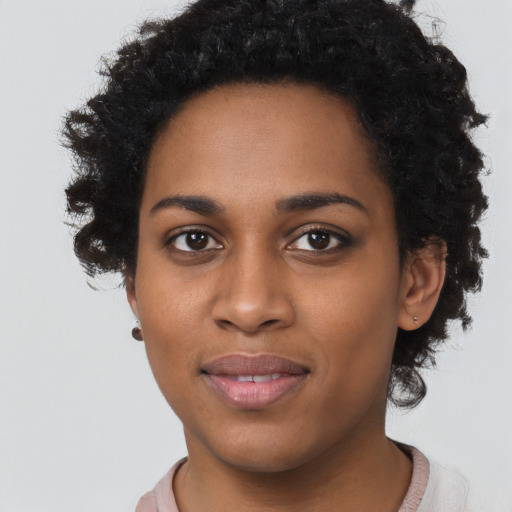 Joyful black young-adult female with short  black hair and brown eyes