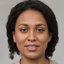 Joyful latino young-adult female with medium  brown hair and brown eyes