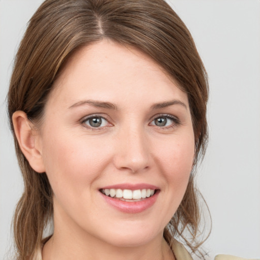 Joyful white young-adult female with medium  brown hair and grey eyes