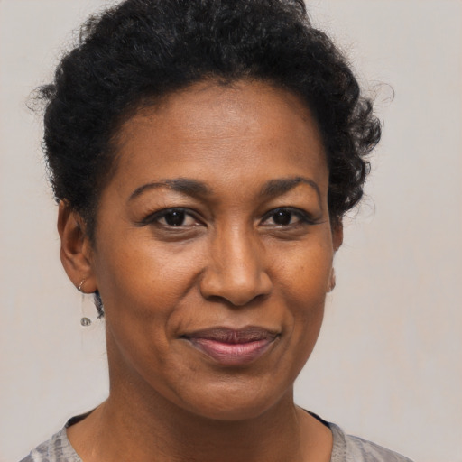 Joyful black adult female with short  brown hair and brown eyes