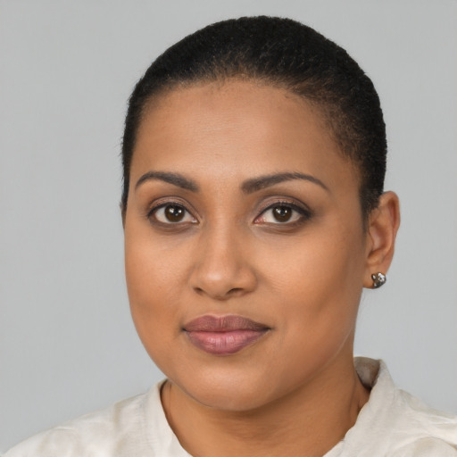 Joyful black young-adult female with short  black hair and brown eyes