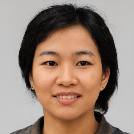 Joyful asian young-adult female with medium  black hair and brown eyes