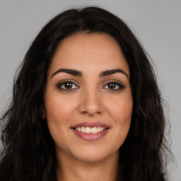 Joyful latino young-adult female with long  brown hair and brown eyes