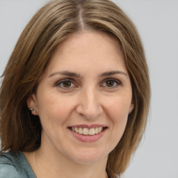 Joyful white adult female with medium  brown hair and brown eyes