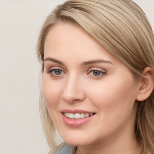 Joyful white young-adult female with long  brown hair and blue eyes