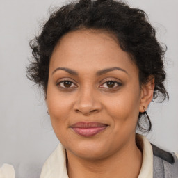 Joyful latino adult female with medium  brown hair and brown eyes