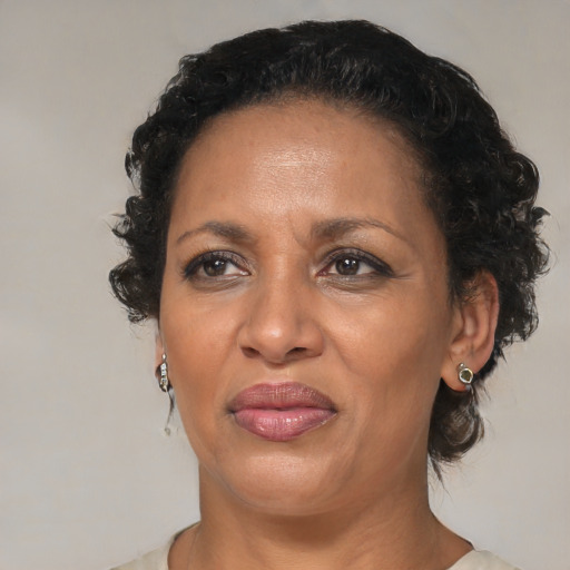 Joyful black adult female with medium  brown hair and brown eyes