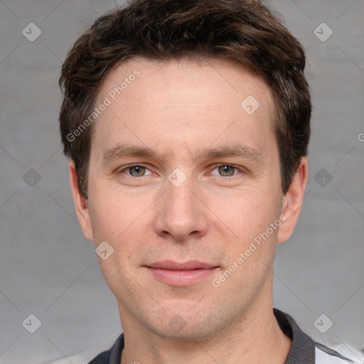 Joyful white adult male with short  brown hair and grey eyes