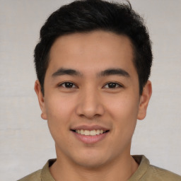 Joyful latino young-adult male with short  brown hair and brown eyes