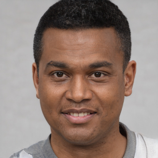 Joyful latino young-adult male with short  black hair and brown eyes