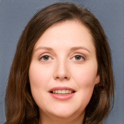 Joyful white young-adult female with long  brown hair and blue eyes