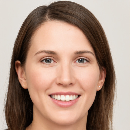 Joyful white young-adult female with long  brown hair and grey eyes