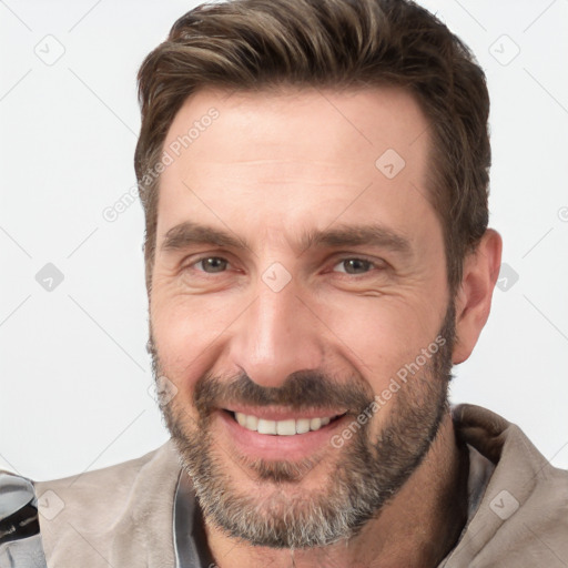 Joyful white adult male with short  brown hair and brown eyes