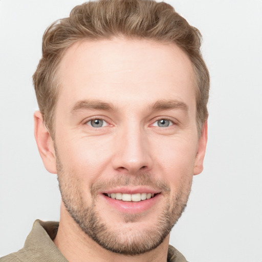 Joyful white young-adult male with short  brown hair and grey eyes