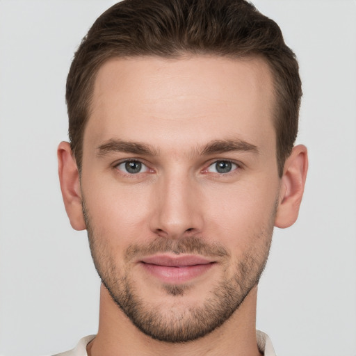 Joyful white young-adult male with short  brown hair and grey eyes