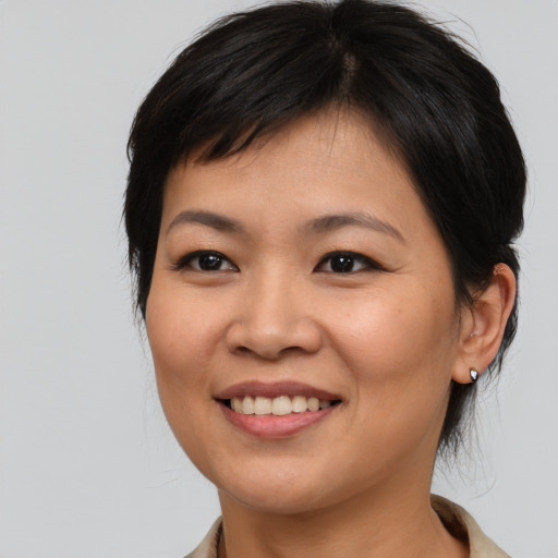 Joyful asian young-adult female with medium  brown hair and brown eyes