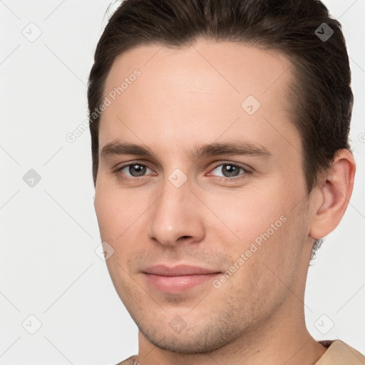 Joyful white young-adult male with short  brown hair and brown eyes