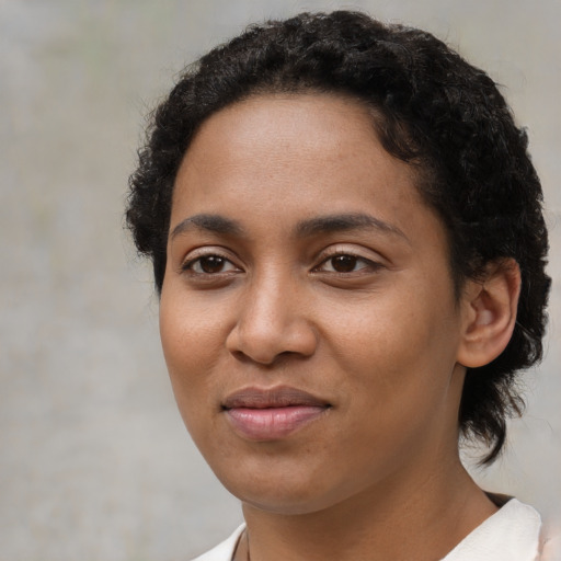 Joyful black young-adult female with short  brown hair and brown eyes