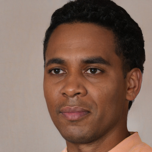 Joyful black young-adult male with short  black hair and brown eyes