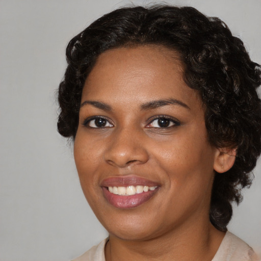 Joyful black young-adult female with medium  brown hair and brown eyes