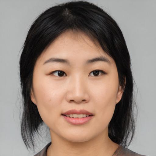 Joyful asian young-adult female with medium  black hair and brown eyes