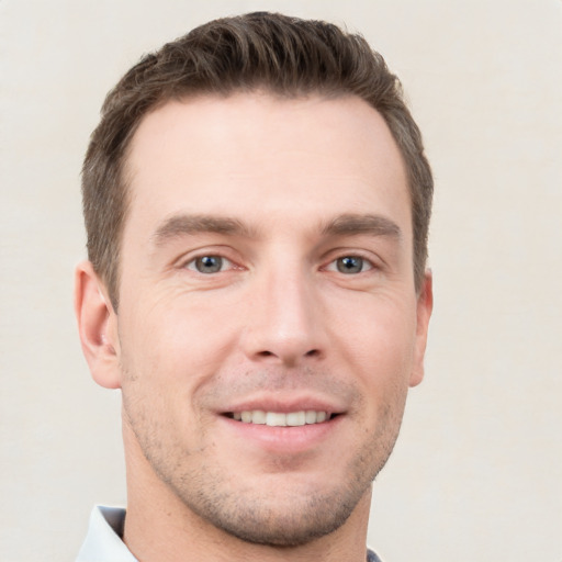 Joyful white young-adult male with short  brown hair and grey eyes