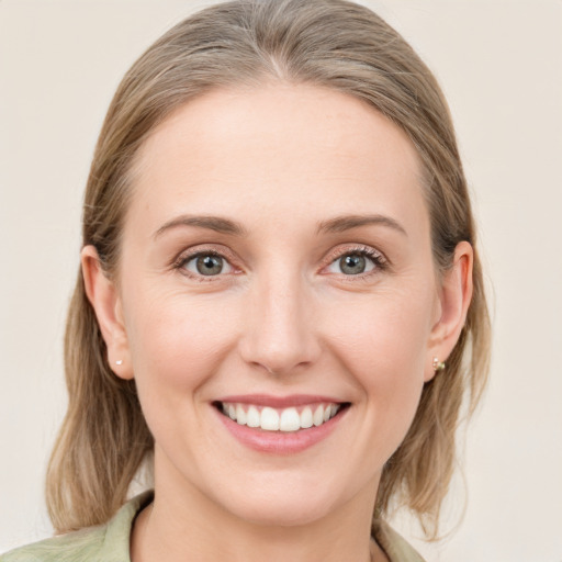 Joyful white young-adult female with medium  brown hair and grey eyes