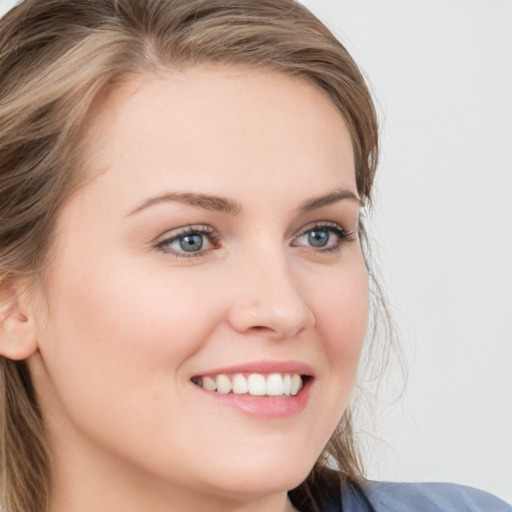 Joyful white young-adult female with long  brown hair and blue eyes