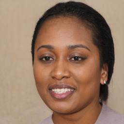 Joyful black young-adult female with long  brown hair and brown eyes